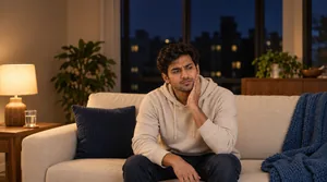 Person resting in a comfortable chair at home in the evening, dealing with persistent throbbing tooth pain